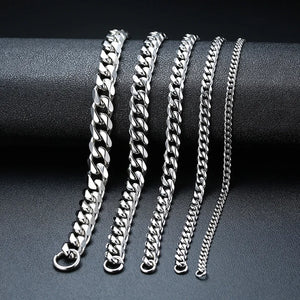 Set of silver chain bracelets on a dark surface