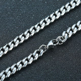 Silver chain necklace on a dark textured surface
